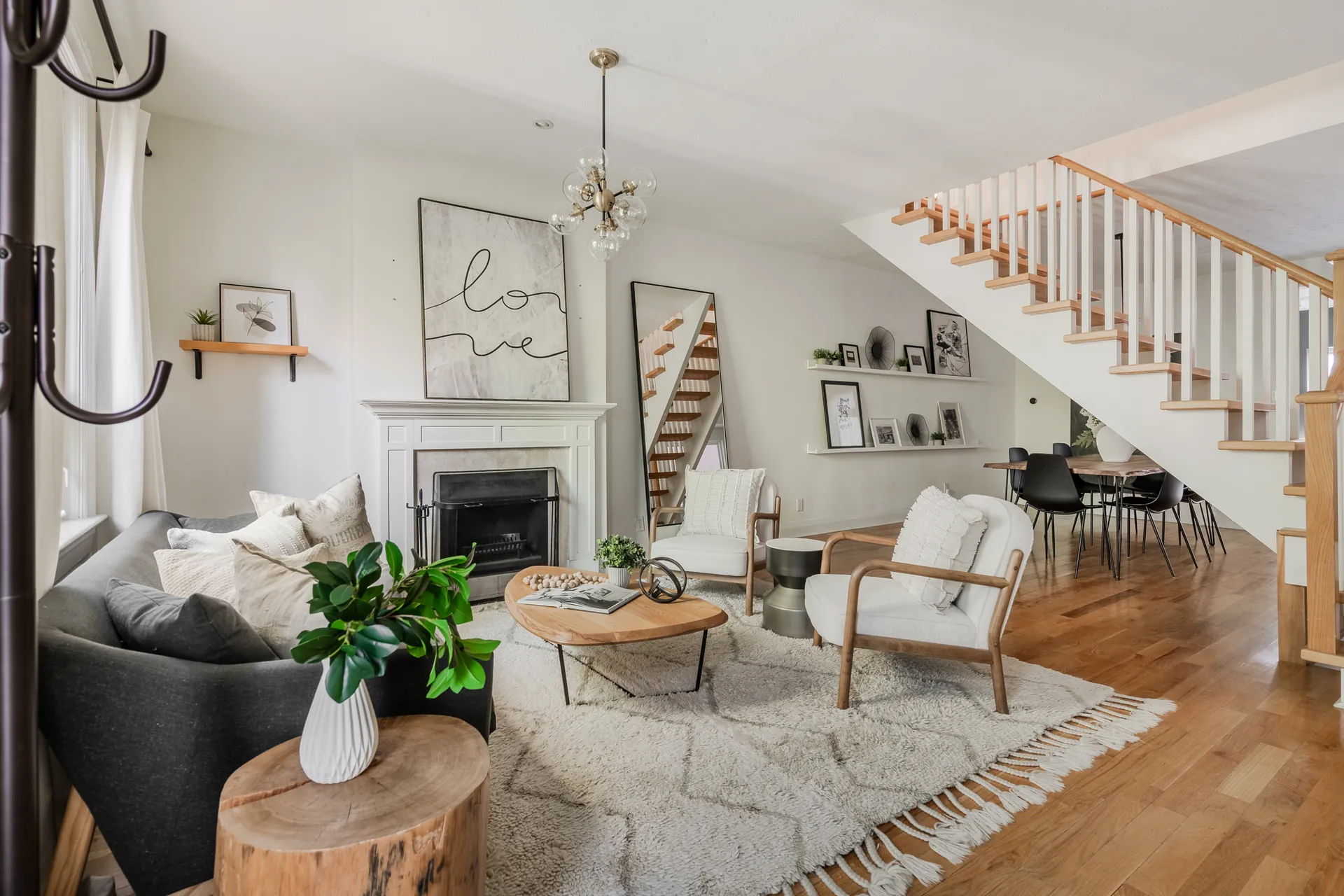 Living room with wood-burning fireplace and the open staircase beyond