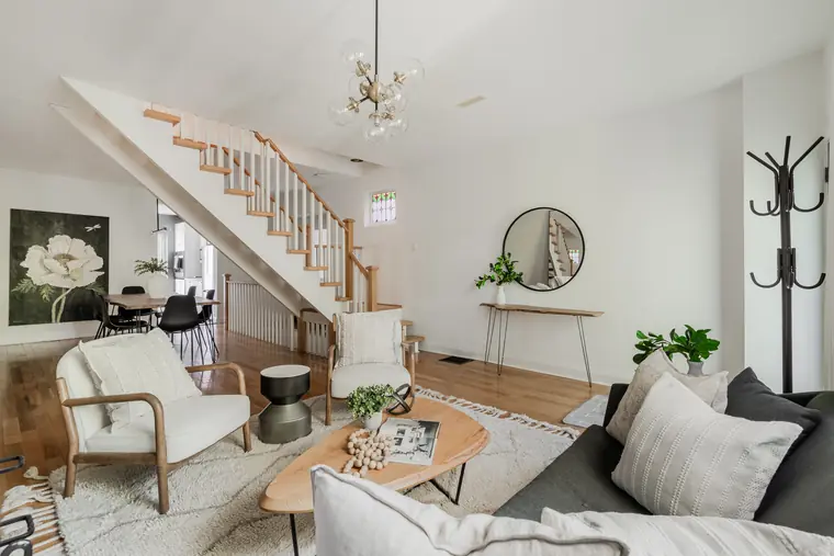 Living room with fireplace, open staircase and dining room
